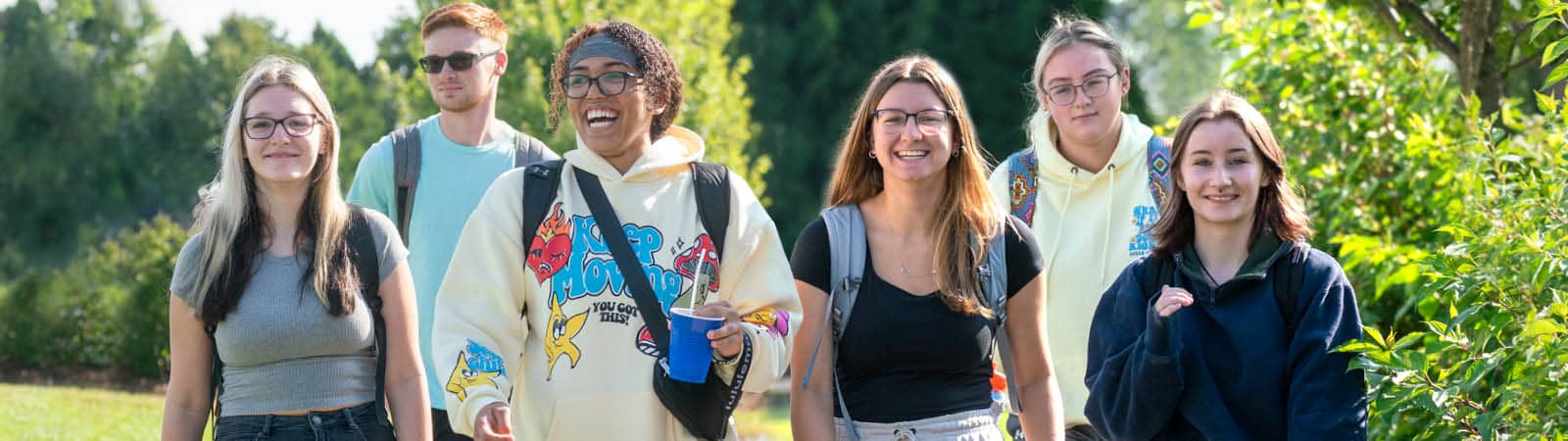 FLCC students walking toward campus on a bright, summer day.